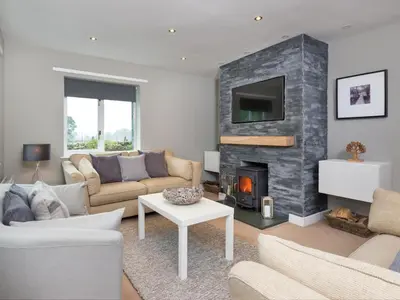 a living room with a couch and a fireplace at 4 Bed in Keswick oc-sz219 in Grange