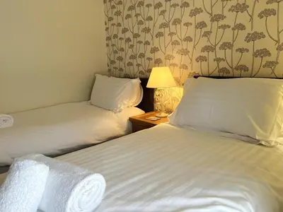 a hotel room with two beds and a table with a lamp at 2 Bed in Keswick SZ379 in Keswick