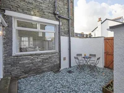 a patio with a table and chairs next to a building at 4 Bed in Keswick oc-sz443 in Keswick