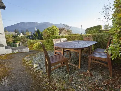 a wooden table and two chairs sitting next to a table at 3 Bed in Keswick oc-sz194 in Braithwaite