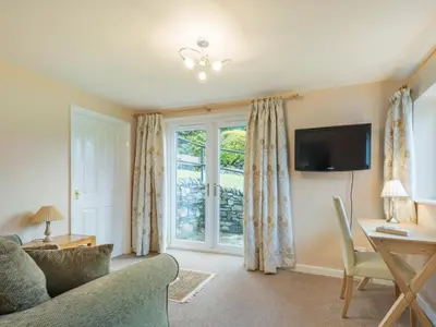 a living room with a couch and a desk and a window at 3 Bed in Keswick oc-sz194 in Braithwaite