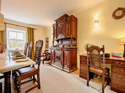 a dining room with a table and a large wooden cabinet at 4 Bed in Penrith oc-sz367 in Dockray