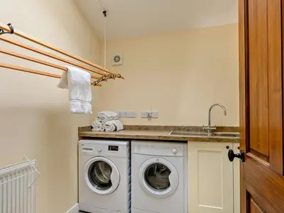 a laundry room with a washing machine and a sink at 4 Bed in Penrith oc-sz367 in Dockray