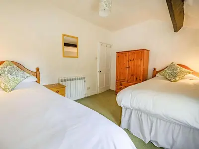 a bedroom with two white beds and a wooden cabinet at 2 Bed in Borrowdale SZ302 in Rosthwaite