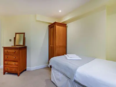 a bedroom with a bed and a dresser and a mirror at 2 Bed in Keswick oc-sz132 in Keswick