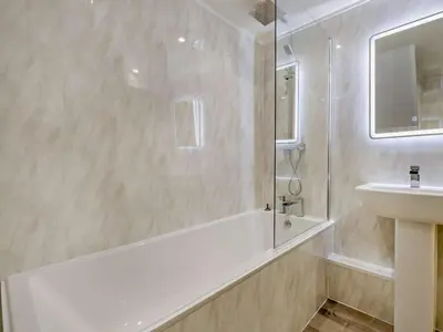 a bathroom with a tub and a sink and a mirror at 2 Bed in Keswick oc-sz132 in Keswick