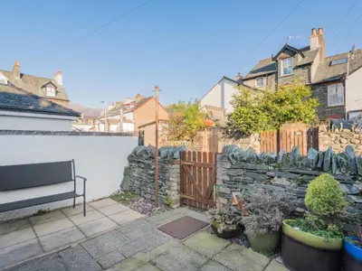 a bench in a yard with a stone fence at 3 Bed in Keswick oc-sz545 in Keswick