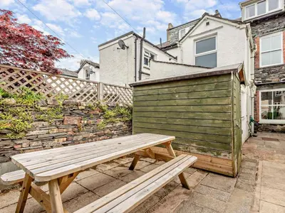 a wooden bench sitting in front of a building at 3 Bed in Keswick oc-sz545 in Keswick