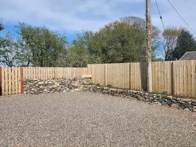 a wooden fence with a stone wall and a wooden pole at 2 Bed in Wasdale oc-sz077 in Santon Bridge