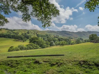 a field of green grass with mountains in the background at 2 Bed in Patterdale SZ470 in Patterdale
