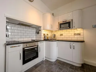 a kitchen with white cabinets and a microwave at 3 Bed in Keswick oc-sz118 in Keswick