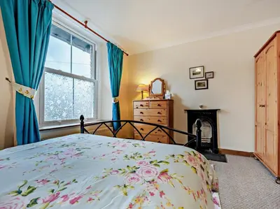 a bedroom with a bed and a fireplace and a window at 2 Bed in Keswick oc-sz417 in Keswick