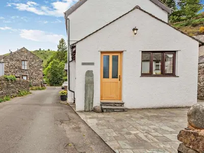 a white house with a orange door on a street at 3 Bed in Keswick oc-sz153 in Braithwaite
