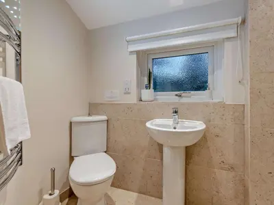 a bathroom with a toilet and a sink and a window at 3 Bed in Penrith oc-sz247 in Dockray