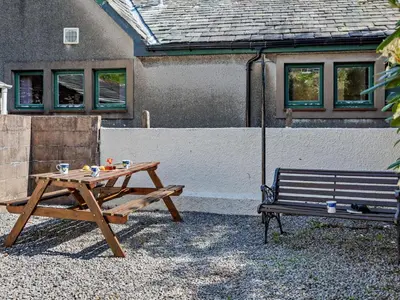 a picnic table and a bench in front of a house at 2 Bed in Keswick oc-sz145 in Braithwaite
