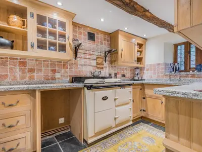 a large kitchen with wooden cabinets and counters at 5 Bed in Holmrook oc-sz259 in Eskdale