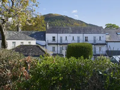 a group of white buildings with a hill in the background at 2 Bed in Keswick SZ027 in Keswick