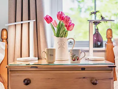 a table with two coffee mugs and flowers on it at 2 Bed in Keswick SZ027 in Keswick