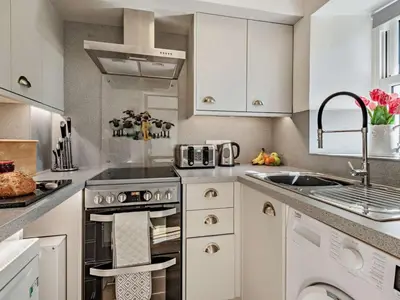 a kitchen with white cabinets and a sink and an oven at 2 Bed in Keswick SZ027 in Keswick