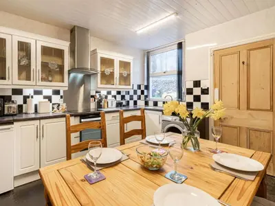 a kitchen with a wooden table with wine glasses at 2 Bed in Holmrook oc-sz464 in Beckfoot
