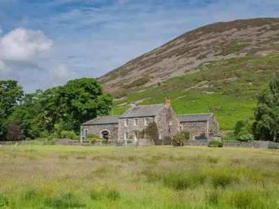 an old house in a field in front of a hill at 2 Bed in Penrith oc-sz218 in Mosedale