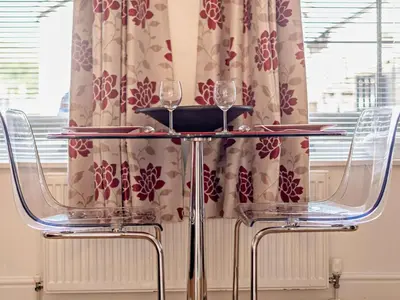 two wine glasses on a table in front of a window at 1 Bed in Keswick SZ127 in Keswick