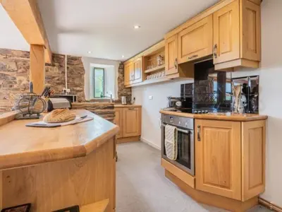 a kitchen with wooden cabinets and a counter top at 2 Bed in Penrith oc-sz092 in Mosedale
