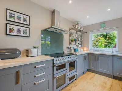 a kitchen with blue cabinets and a stove top oven at 3 Bed in Keswick oc-sz029 in Keswick