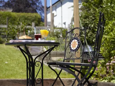 a table and a chair with a plate of food and drinks at 2 Bed in Keswick SZ011 in Keswick