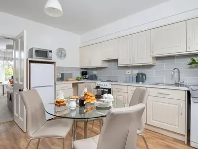 a kitchen with a glass table and white cabinets at 3 Bed in Keswick oc-sz337 in Keswick