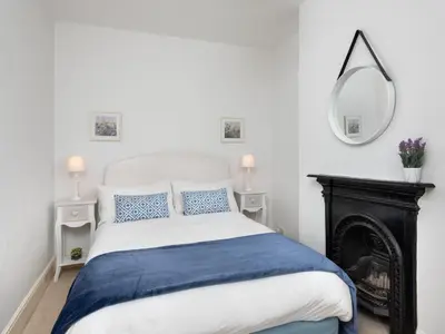 a bedroom with a bed with a mirror and a fireplace at 3 Bed in Keswick oc-sz337 in Keswick