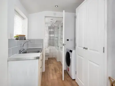 a white kitchen with a sink and a washing machine at 3 Bed in Keswick oc-sz337 in Keswick