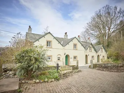 a large white house with a bench in front of it at 3 Bed in Keswick oc-sz169 in Applethwaite