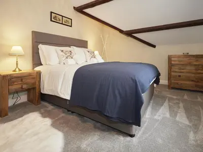 a bedroom with a large bed and a wooden dresser at 3 Bed in Keswick oc-sz169 in Applethwaite
