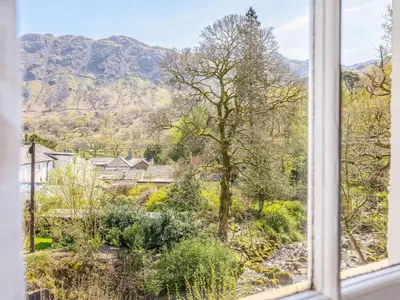 a window view of a garden with mountains in the background at 3 Bed in Borrowdale SZ234 in Rosthwaite