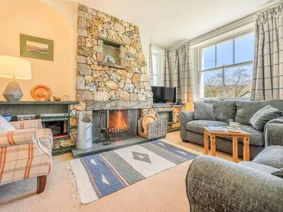 a living room with a fireplace and a stone wall at 3 Bed in Borrowdale SZ234 in Rosthwaite