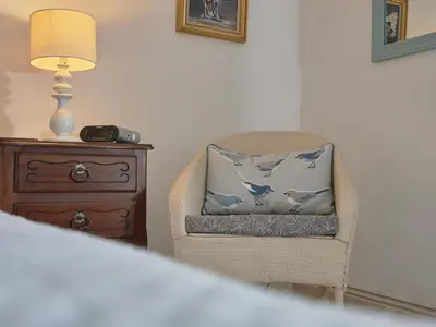 a chair with a pillow on it next to a lamp at 2 Bed in Workington oc-sz323 in Camerton