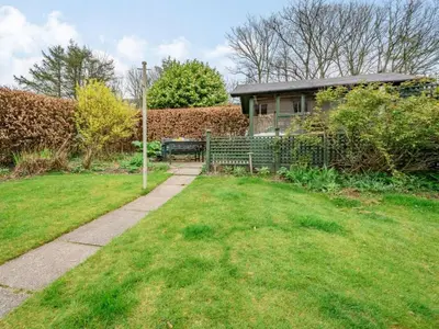 a garden with a bench in front of a house at 3 Bed in Keswick oc-84638 in Keswick