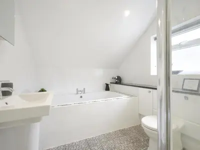 a white bathroom with a tub and a sink at 4 Bed in Keswick oc-sz220 in Keswick