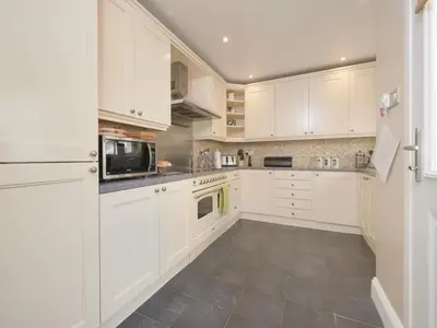 a white kitchen with white cabinets and a tile floor at 4 Bed in Keswick oc-sz220 in Keswick