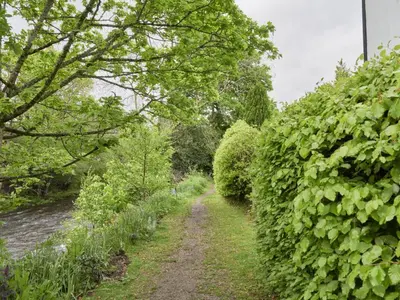 a path through a hedge next to a river at 2 Bed in Keswick oc-sz188 in Keswick