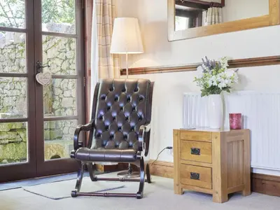 a black chair sitting in a room next to a table at 1 Bed in Eskdale SZ471 in Beckfoot