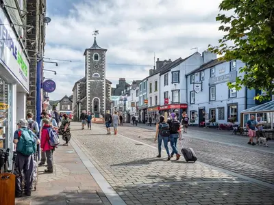 a group of people walking down a cobblestone street at 2 Bed in Keswick oc-sz199 in Applethwaite