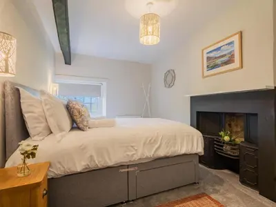 a bedroom with a large bed and a fireplace at 2 Bed in Keswick oc-sz199 in Applethwaite