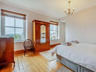 a bedroom with a bed and a dresser and a chair at 4 Bed in Cockermouth oc-sz037 in Cockermouth