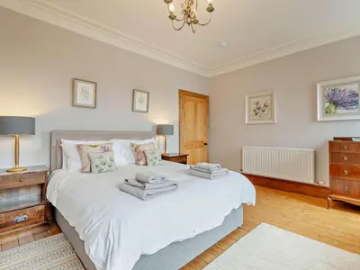 a bedroom with a large white bed and a chandelier at 4 Bed in Cockermouth oc-sz037 in Cockermouth