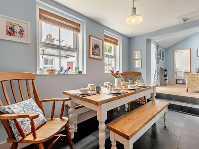 a dining room with a table and chairs and windows at 4 Bed in Cockermouth oc-sz037 in Cockermouth