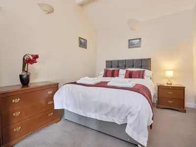 a bedroom with a bed with two night stands and a dresser at 2 Bed in Cockermouth oc-sz588 in Buttermere