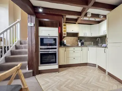 a kitchen with white cabinets and a staircase at 2 Bed in Cockermouth oc-sz588 in Buttermere