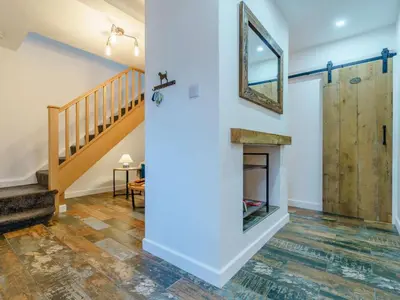a living room with a fireplace and a wooden door at 4 Bed in Seascale oc-85807 in Gosforth